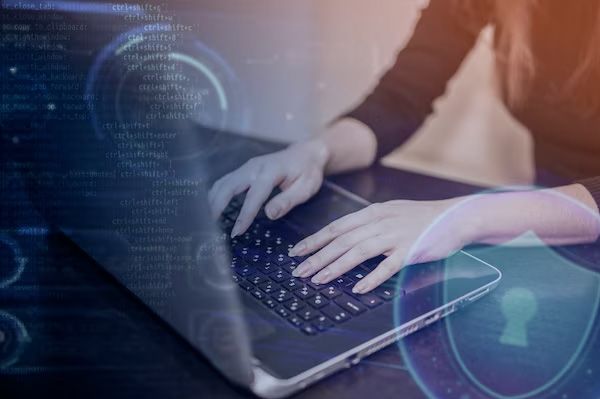 Hands typing on a laptop keyboard